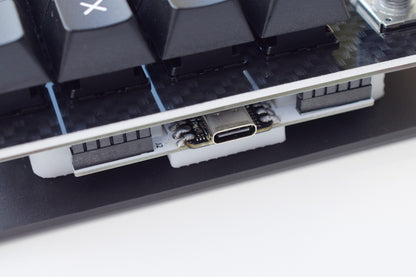 Close-up of a mechanical keyboard with USB cable connection on a white background